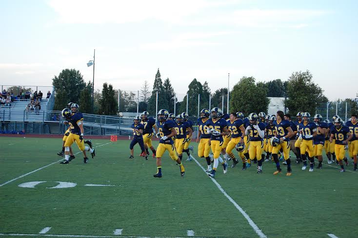 The varsity football team comes out on the field prior to Lincoln's first game against Santa Teresa on September 12.