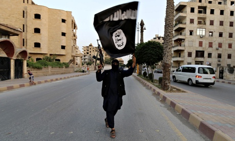 This photograph from Stringer/Reuters shows an Islamic State fighter with his weapon in one hand, and an ISIL flag in the other.