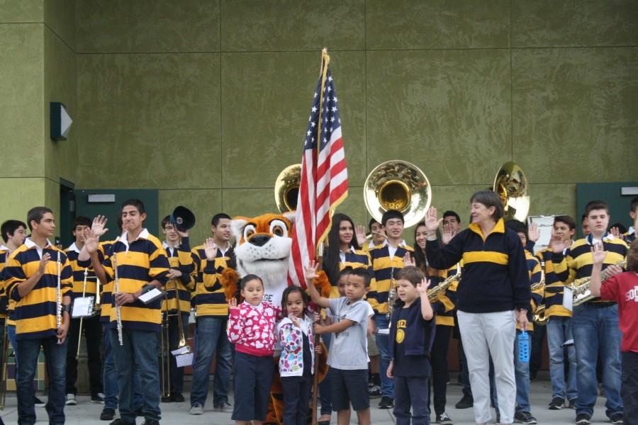Lincolns wind ensemble line up with Traces mascot in the middle during the flag raising.