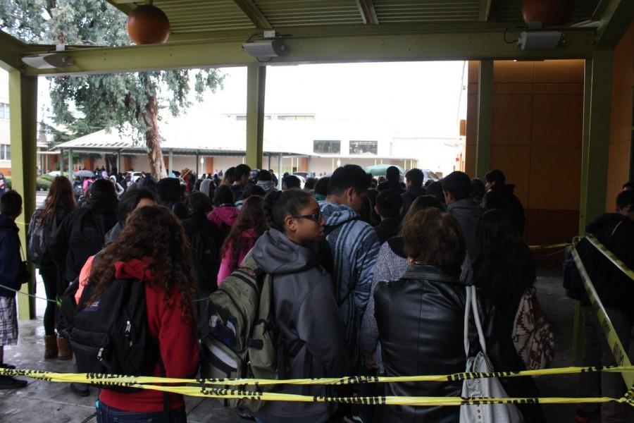 Students wait in the lunch line, which was moved underneath the theater overhang.