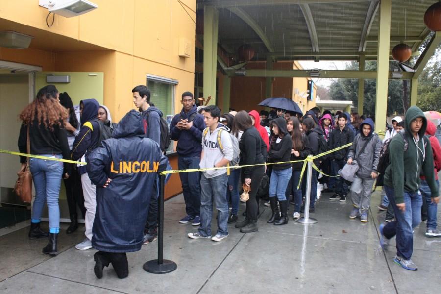 Students wait in the lunch line, which was moved underneath the theater overhang.
