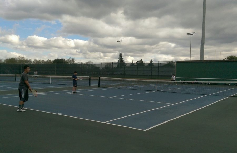 Keahooi Hung and David Zhong play a match against Jared Devra during tennis practice.