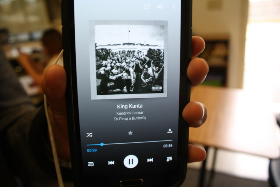 A student's phone displays the song 