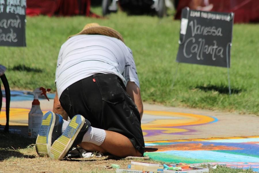 A man wares a hat to avoid the sun while completing his chalk art square.
September 19th 2015
(Juan Alcala / Lincoln Lion Tales)