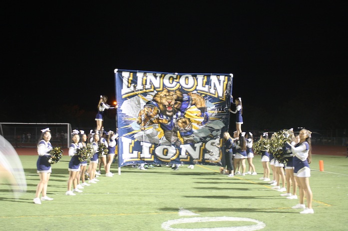 Lioncoln cheerleaders holding up the Lincoln Lion banner waiting for the players to come out. sept. 25, 2015